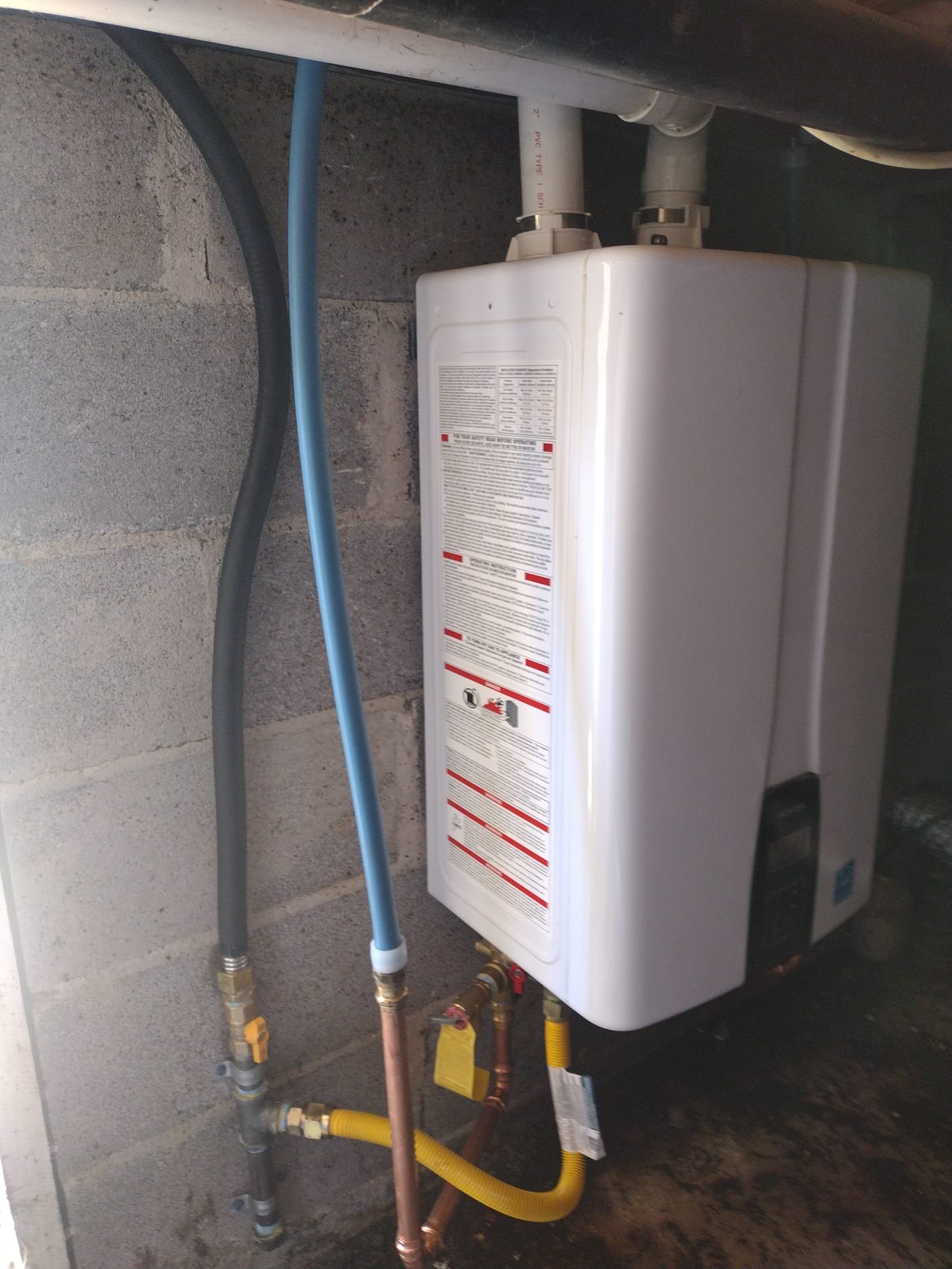 Tankless water heater installed on a concrete wall