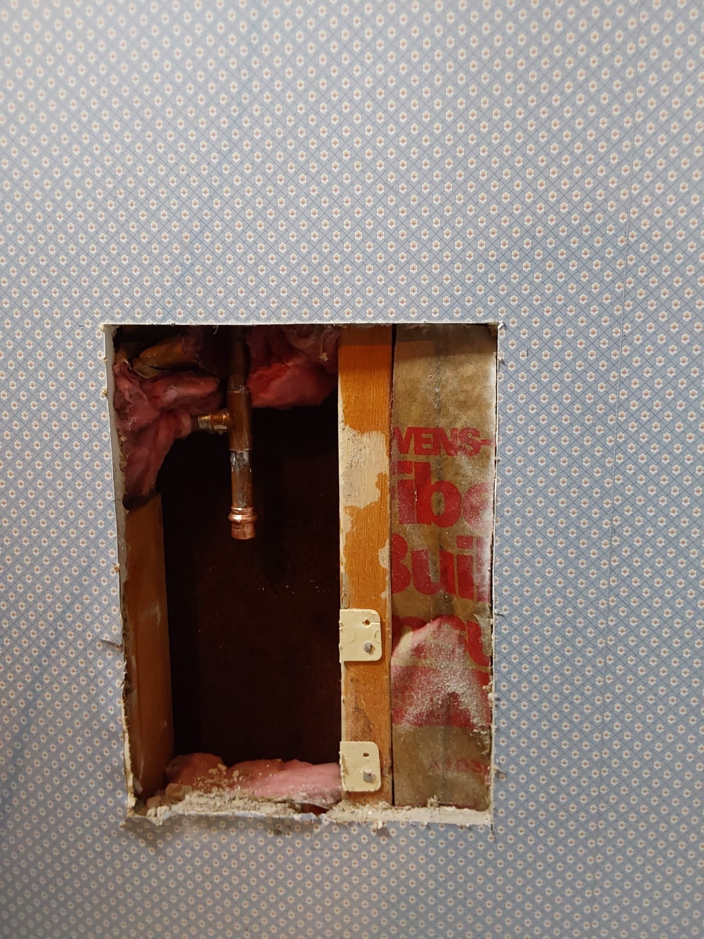 During Repair – Exposing a neatly installed copper pipe section and insulation