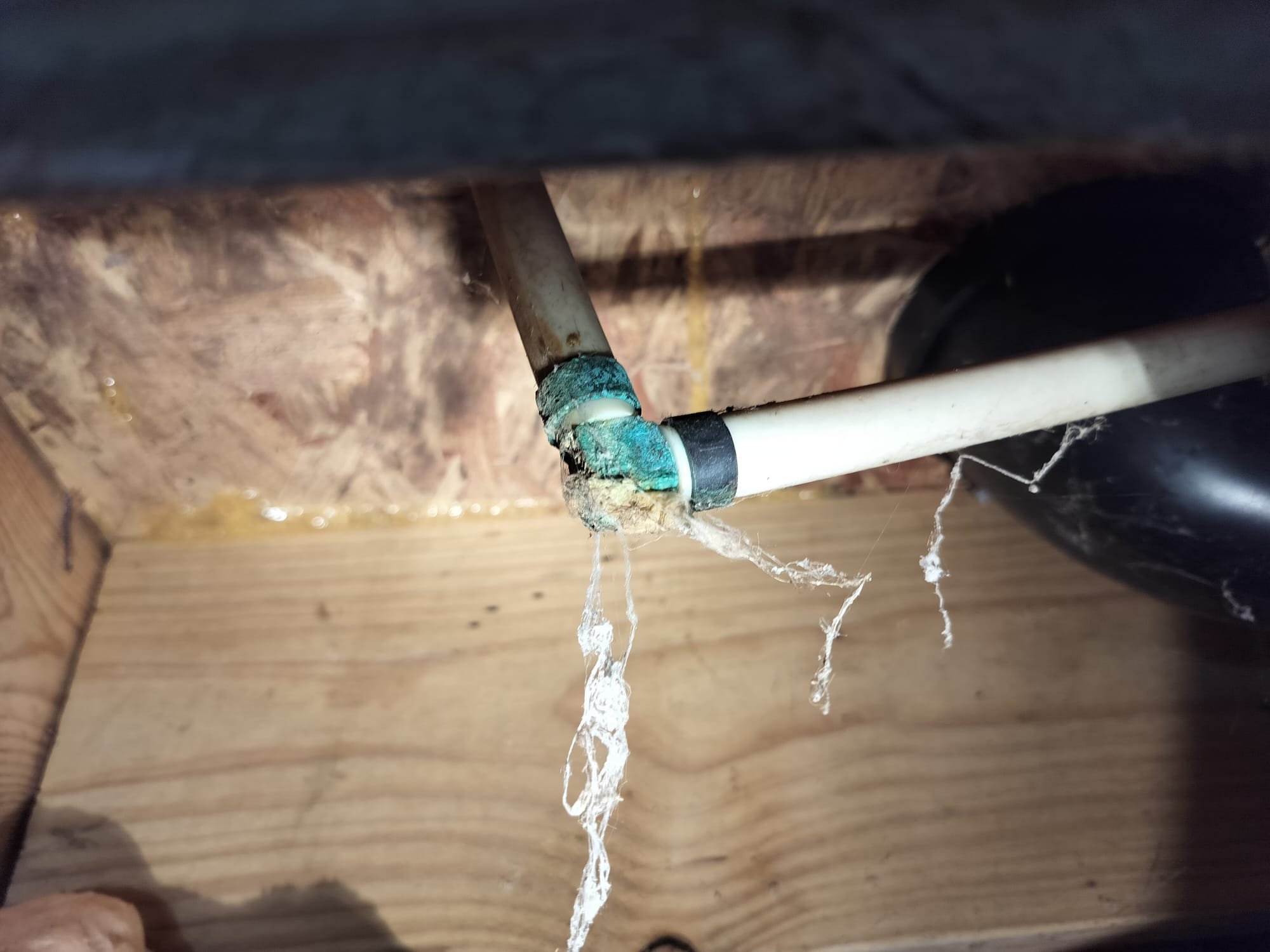 Visible leak before repair: A section of plumbing shows water dripping from a joint, with signs of corrosion and water damage in the surrounding area.