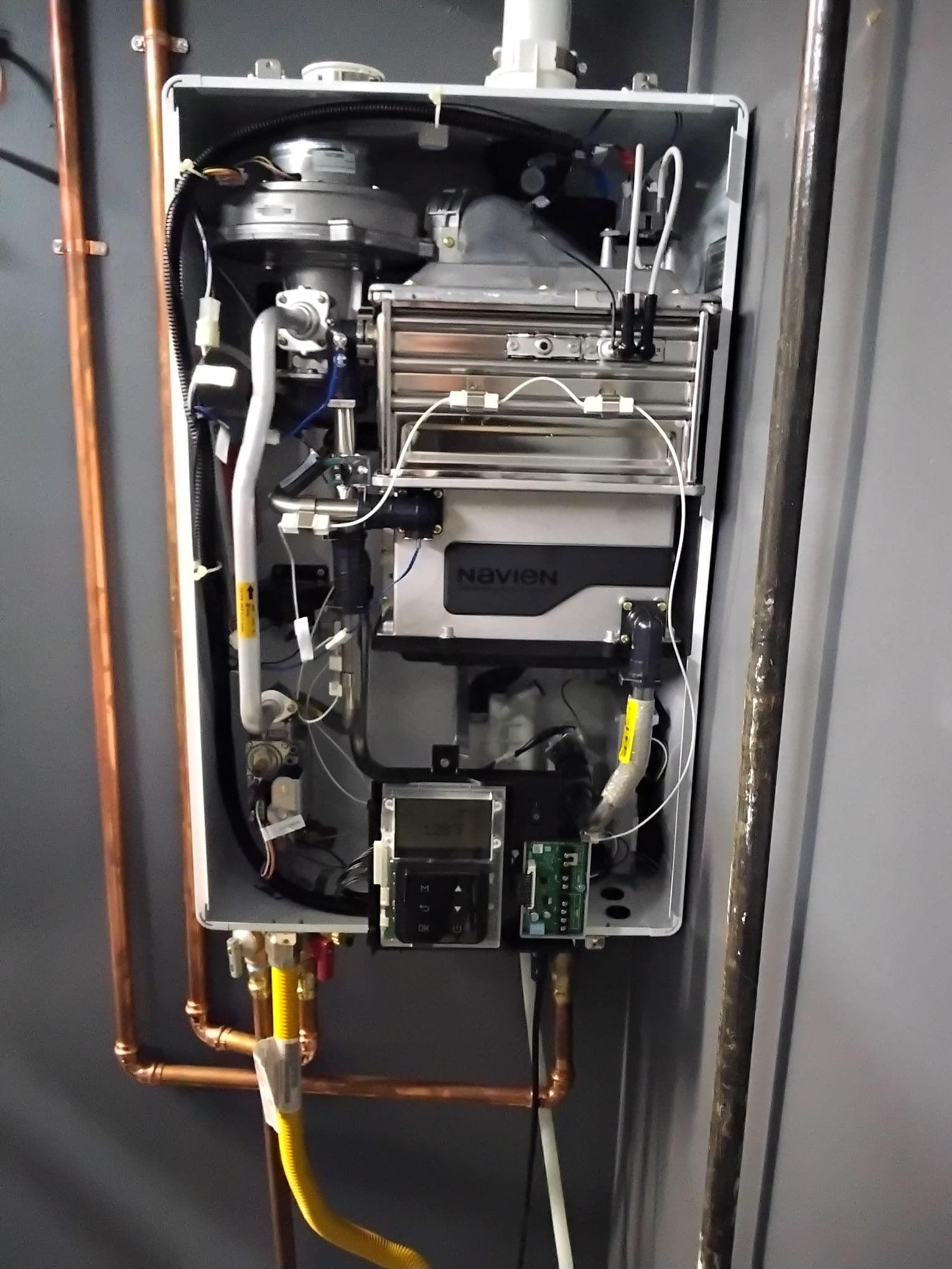 Interior view of a Navien tankless water heater showing a well-installed unit after recent maintenance