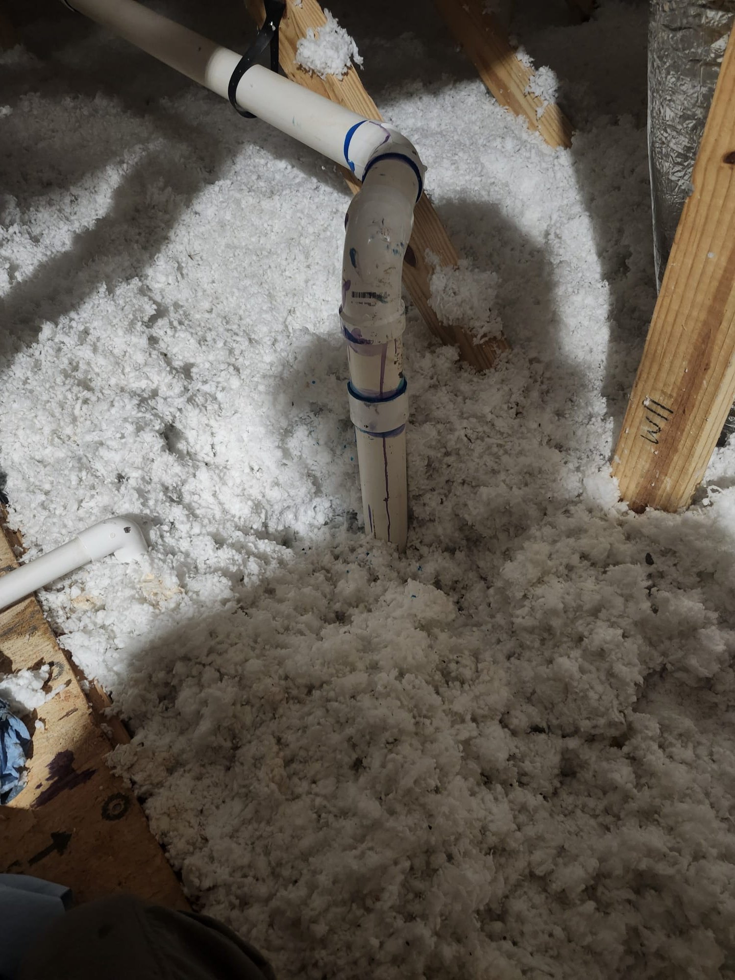 Plumbing work in an attic with new PVC pipe connections
