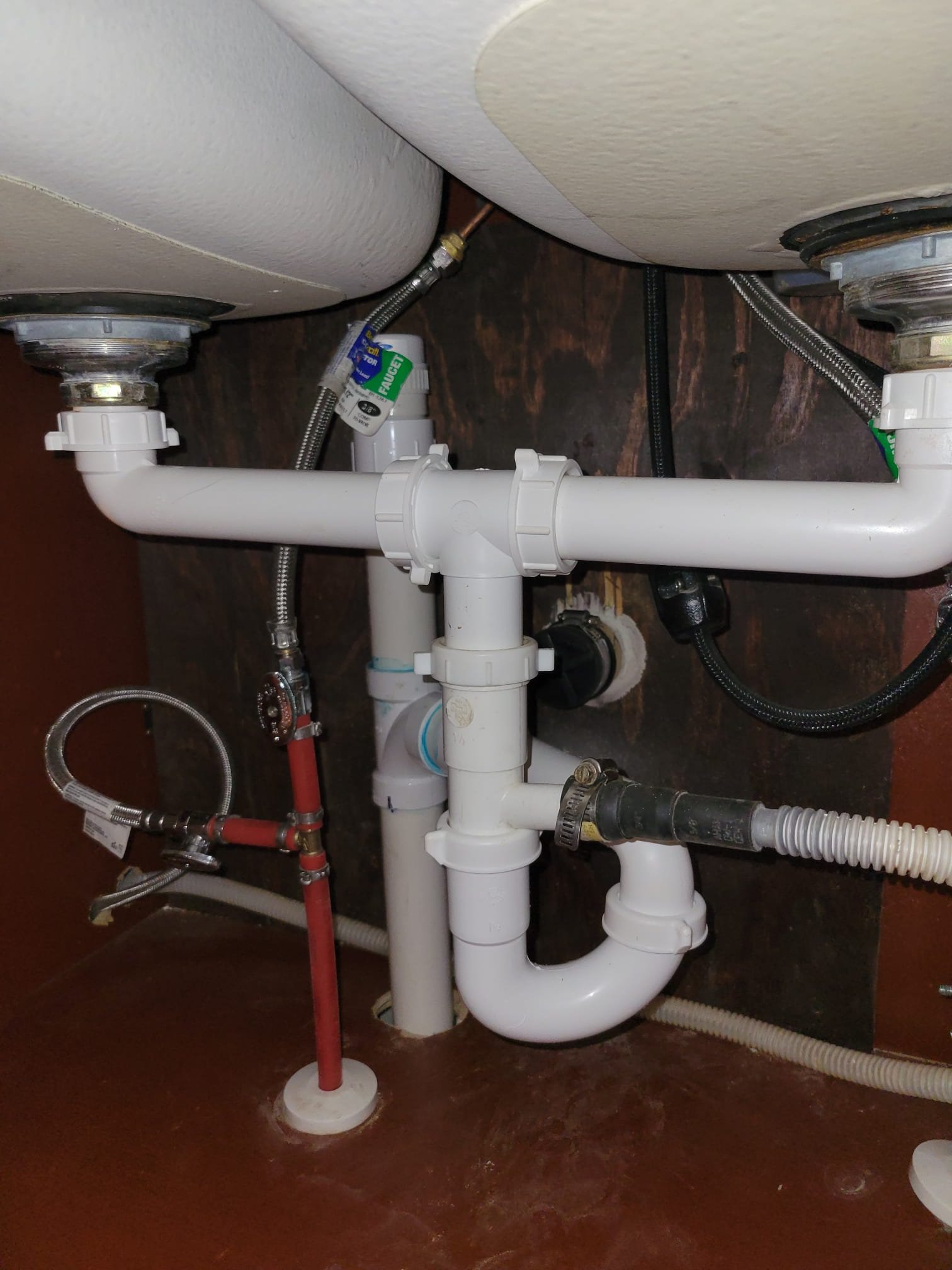 Newly installed sink drain including P-trap, center outlet, and dishwasher hose tailpiece