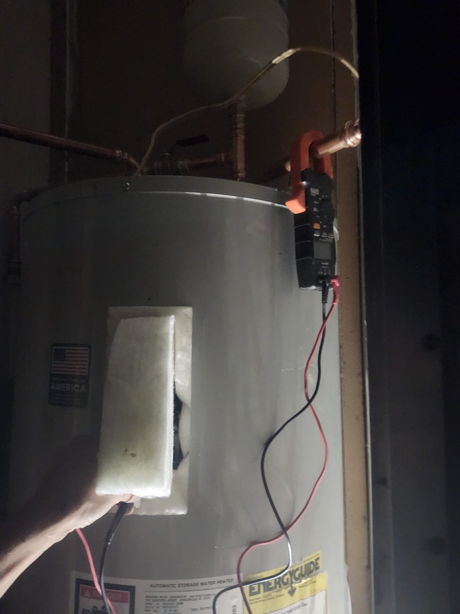 Using a clamp meter to verify the water heater’s electrical connections
