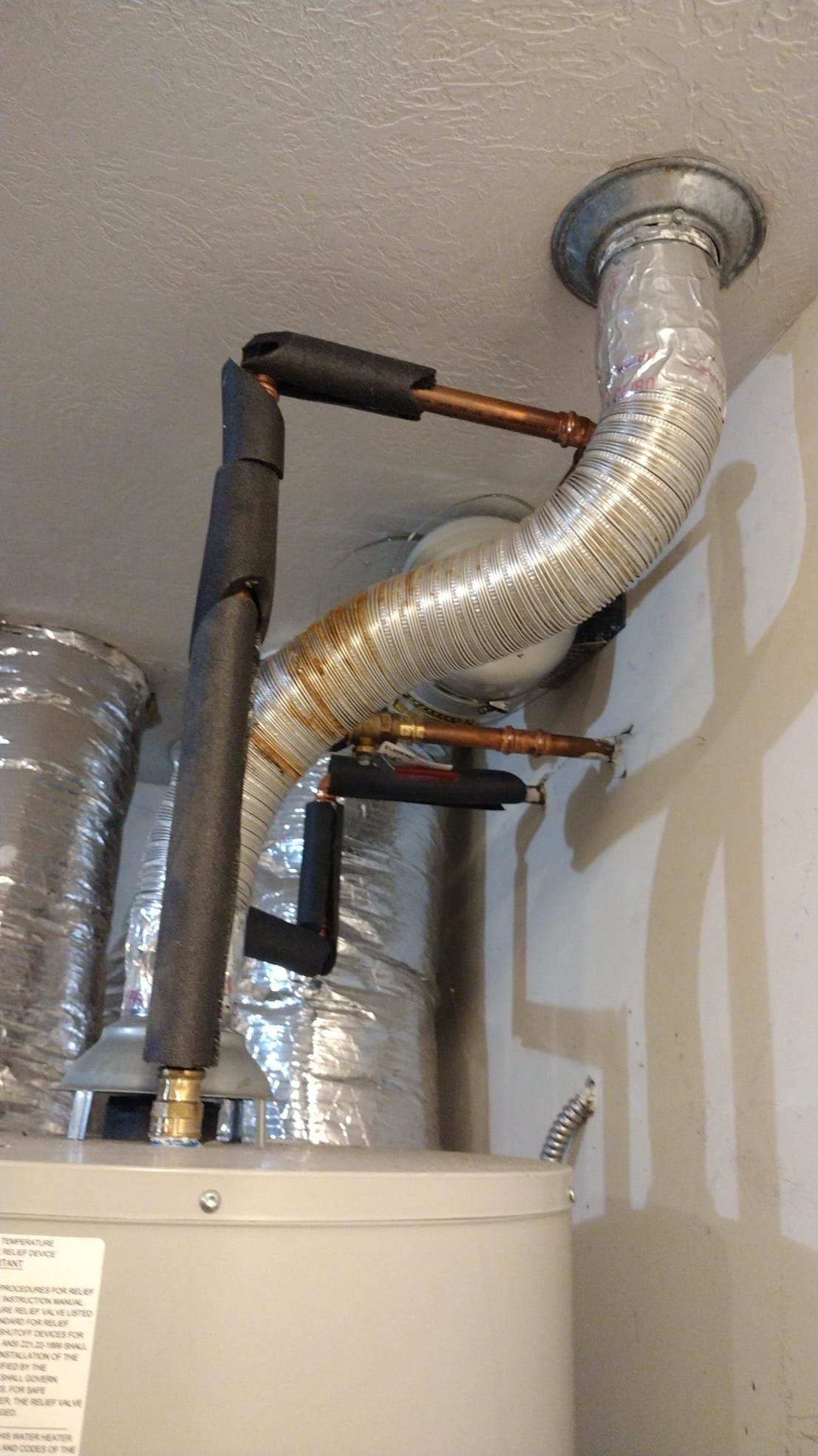 Insulated copper pipes connecting to the water heater