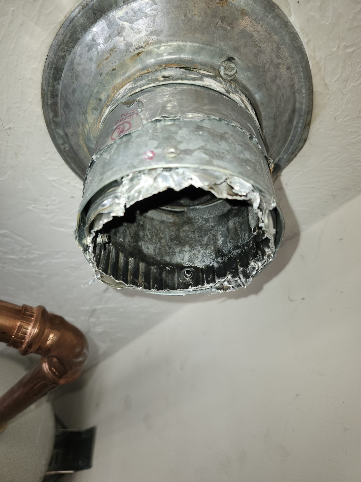 Old vent pipe with jagged edge and corrosion