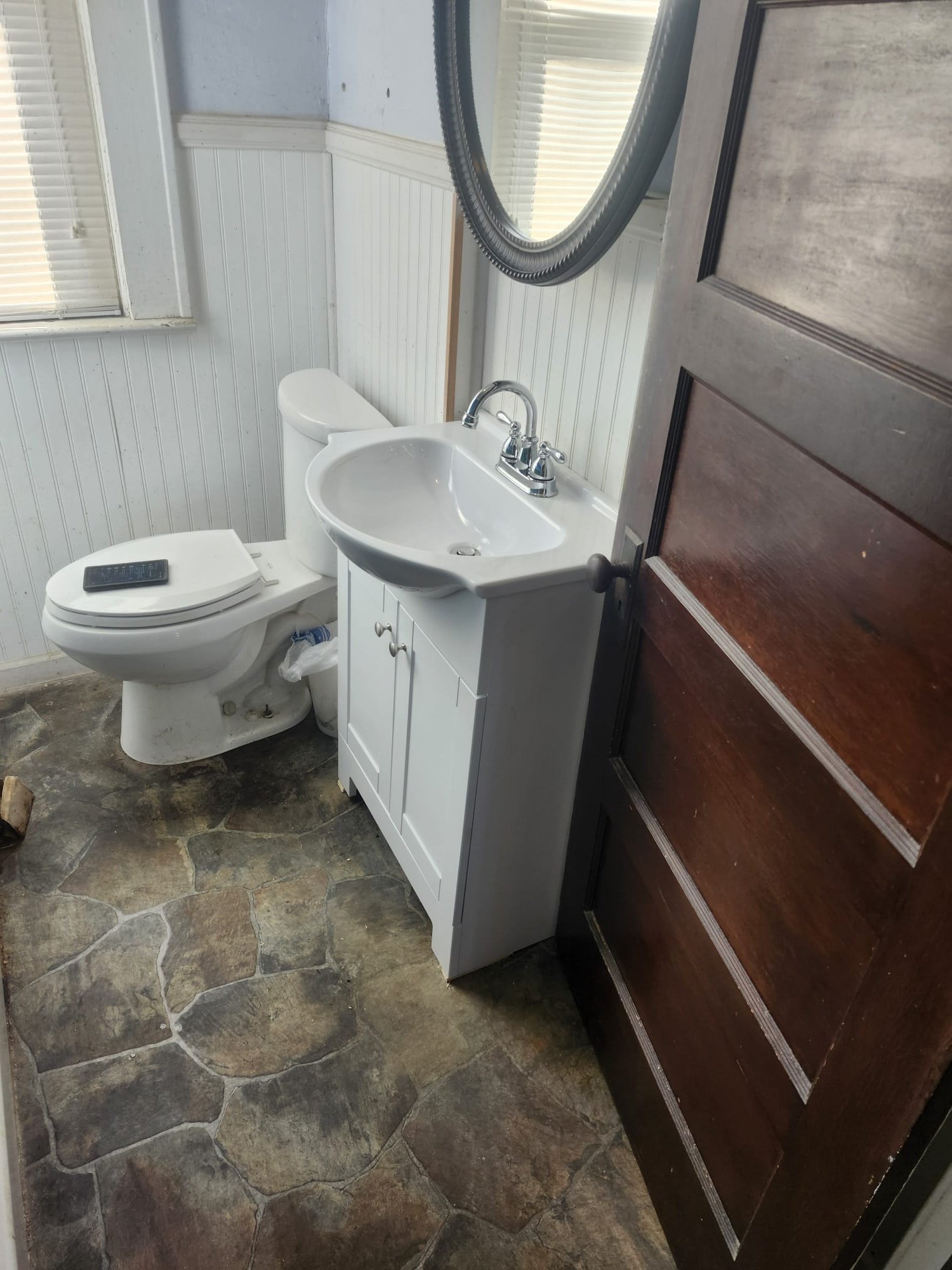 Freshly installed white vanity with modern faucet in a small bathroom