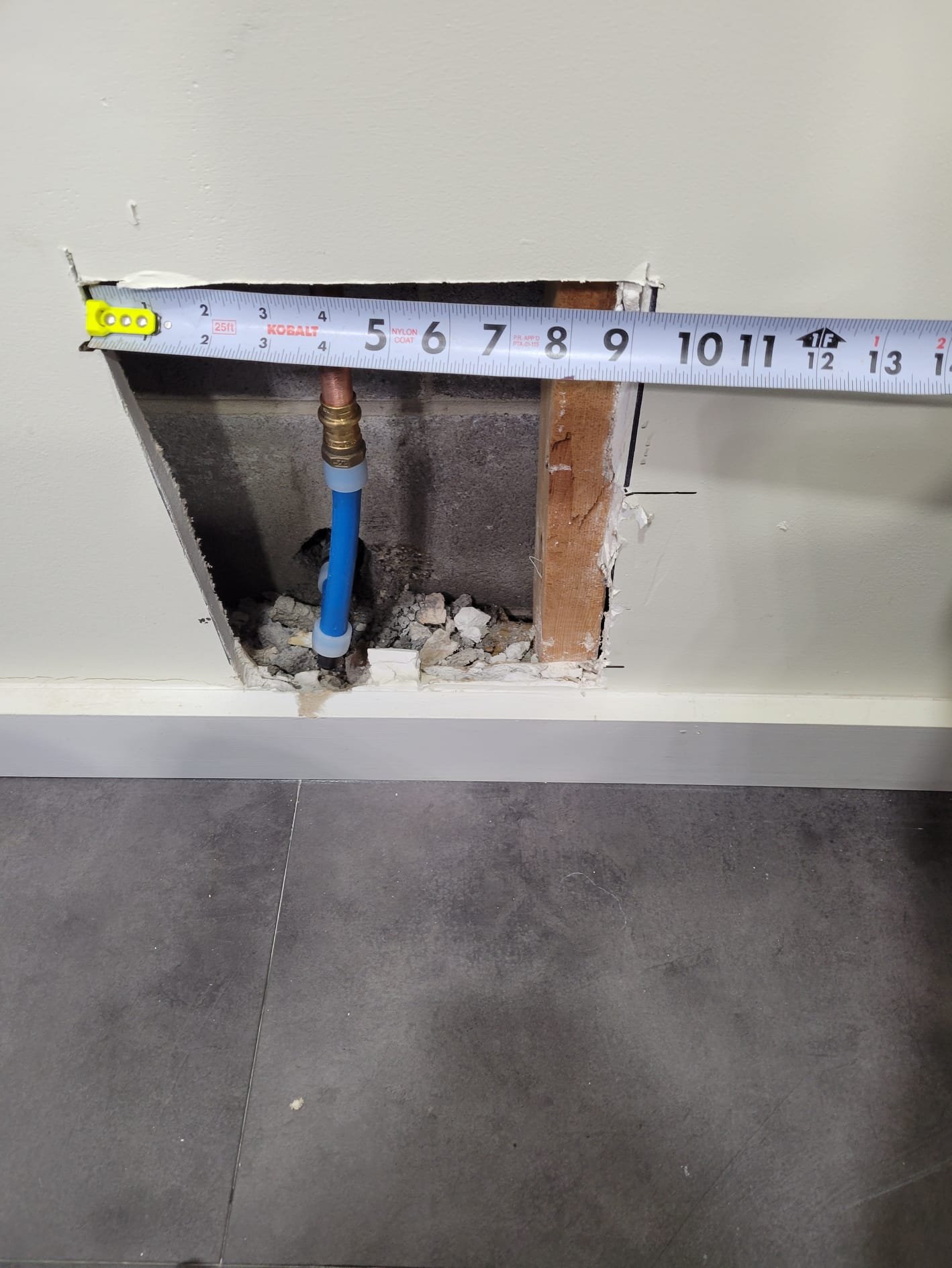 Close-up of new PEX-to-copper connection inside wall cavity