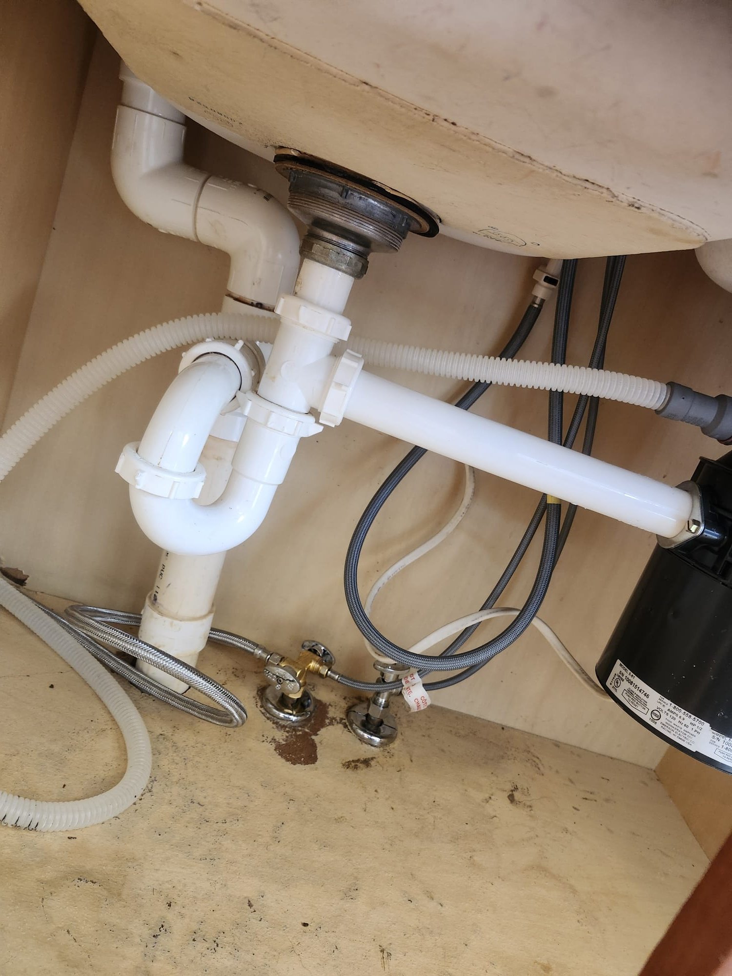 Under-sink plumbing neatly organized after the installation