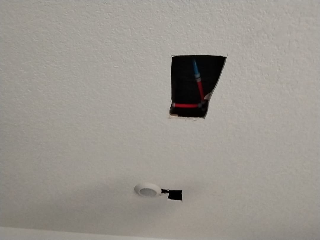 Ceiling cut-out revealing PEX pipes