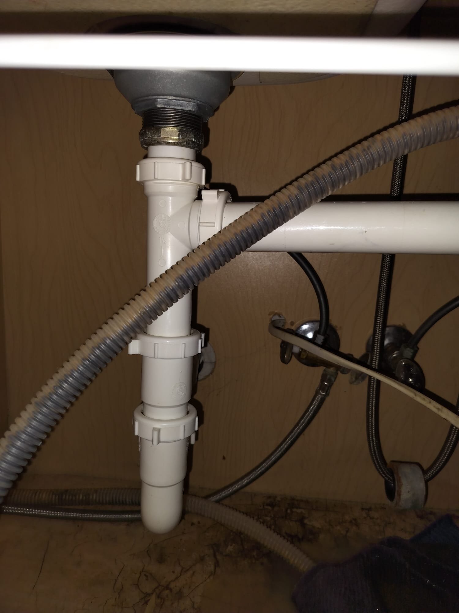 Clean white PVC drain pipes and fittings under a sink