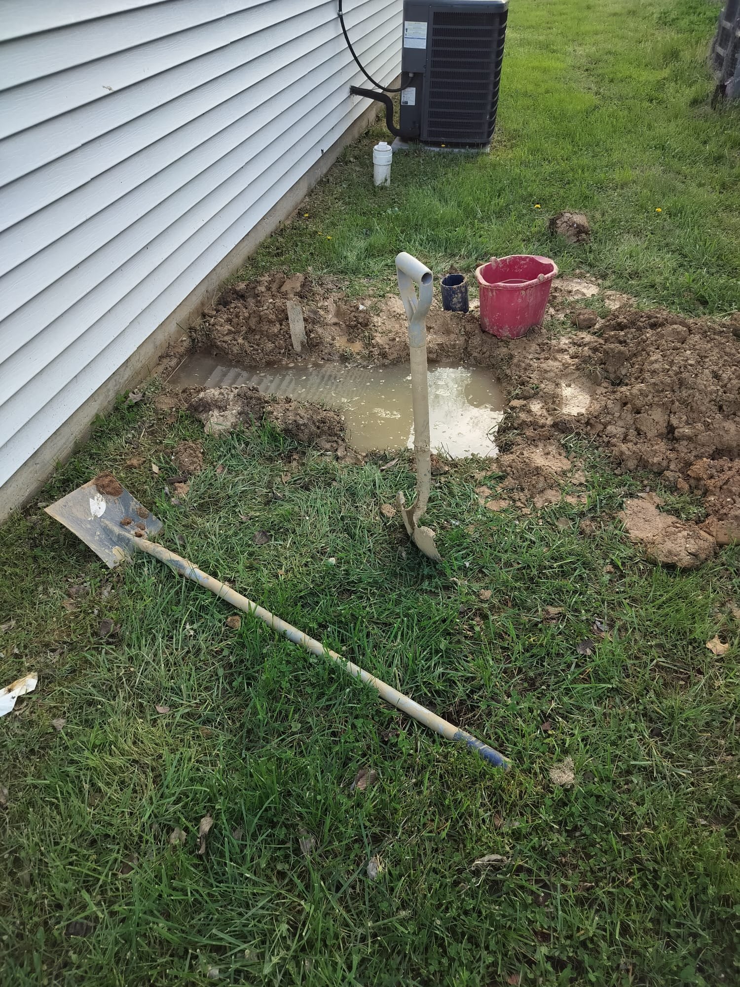 Outdoor trench showing the exposed water line beside a home
