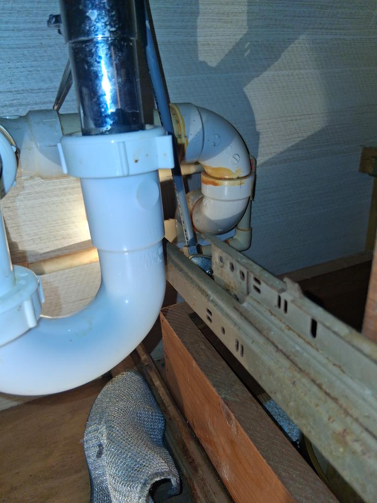 Clean PVC and metal piping under a sink