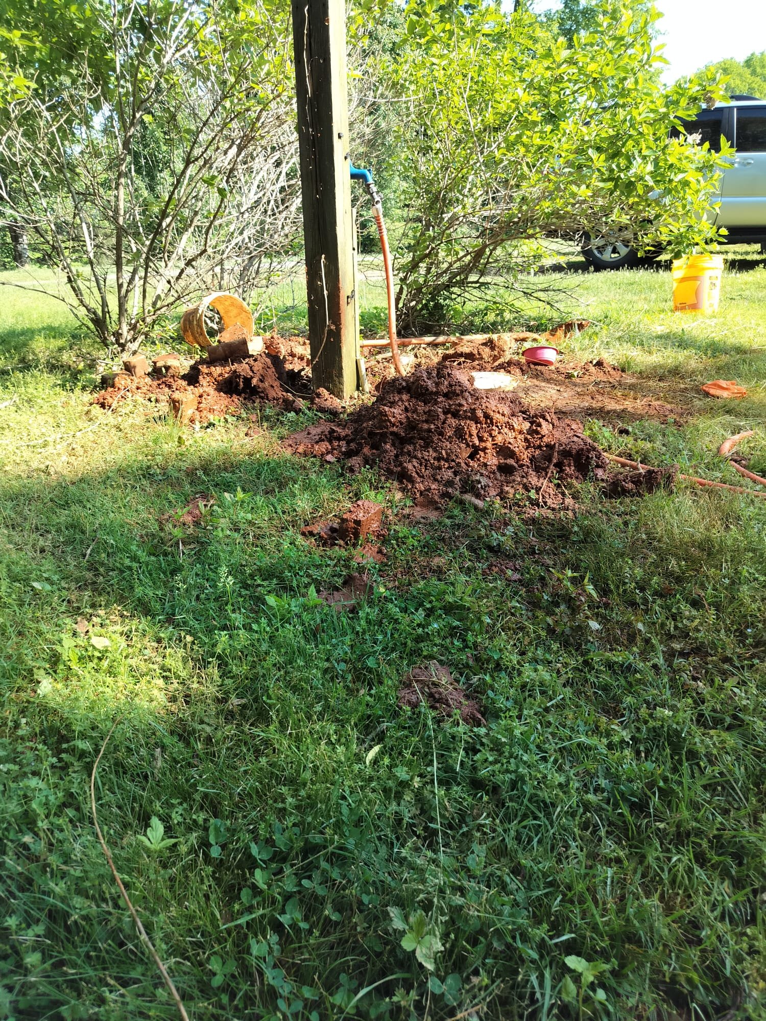 New outdoor faucet and copper piping installed on a wooden post