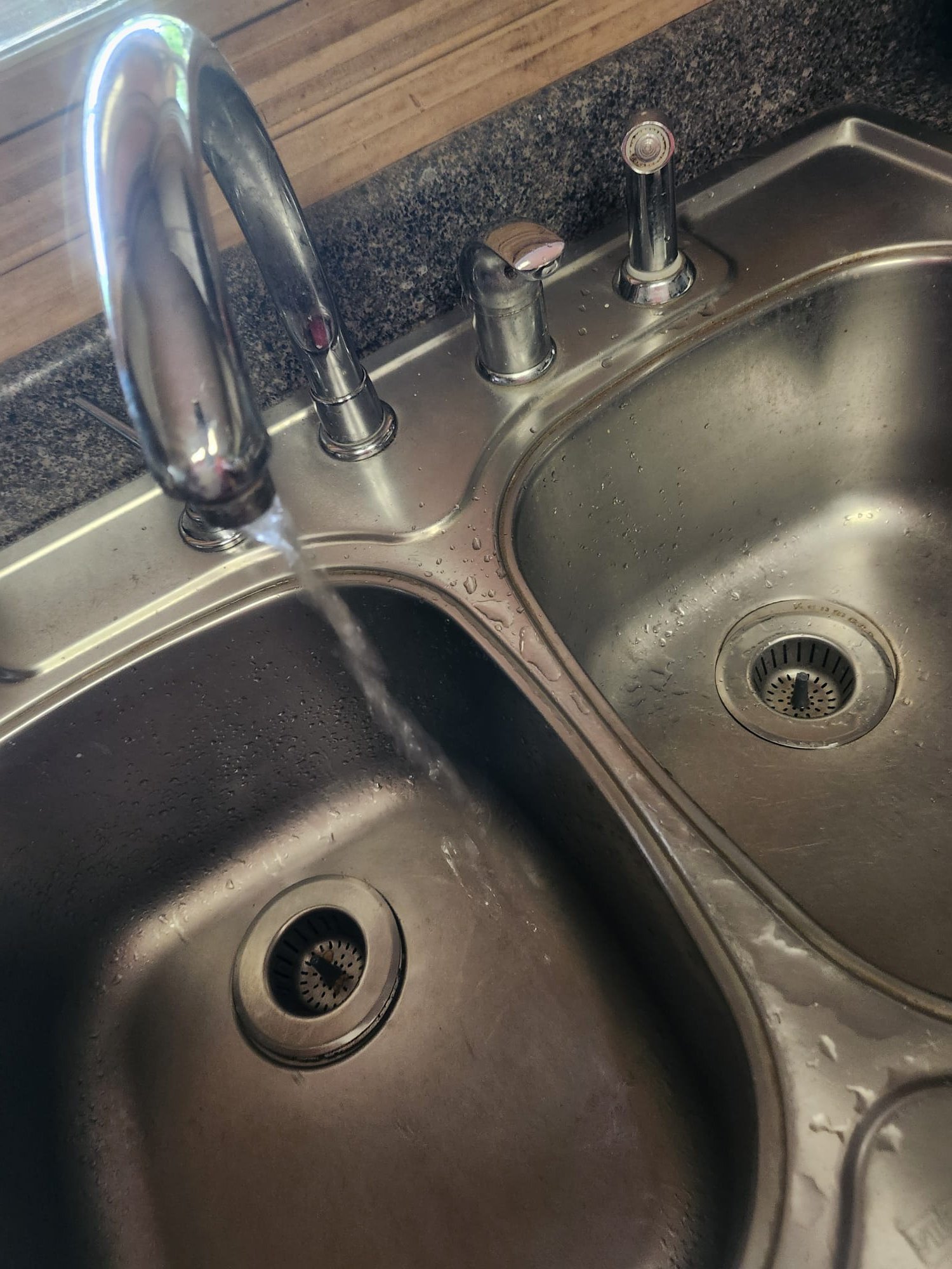 A stainless steel double kitchen sink with a modern chrome faucet