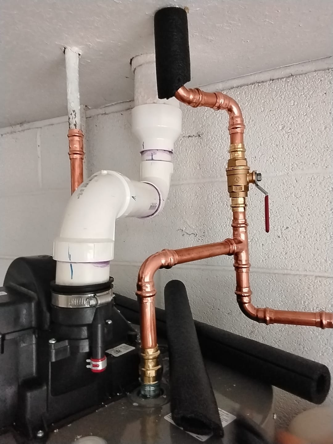 Close-up of new copper piping and PVC fittings after installation