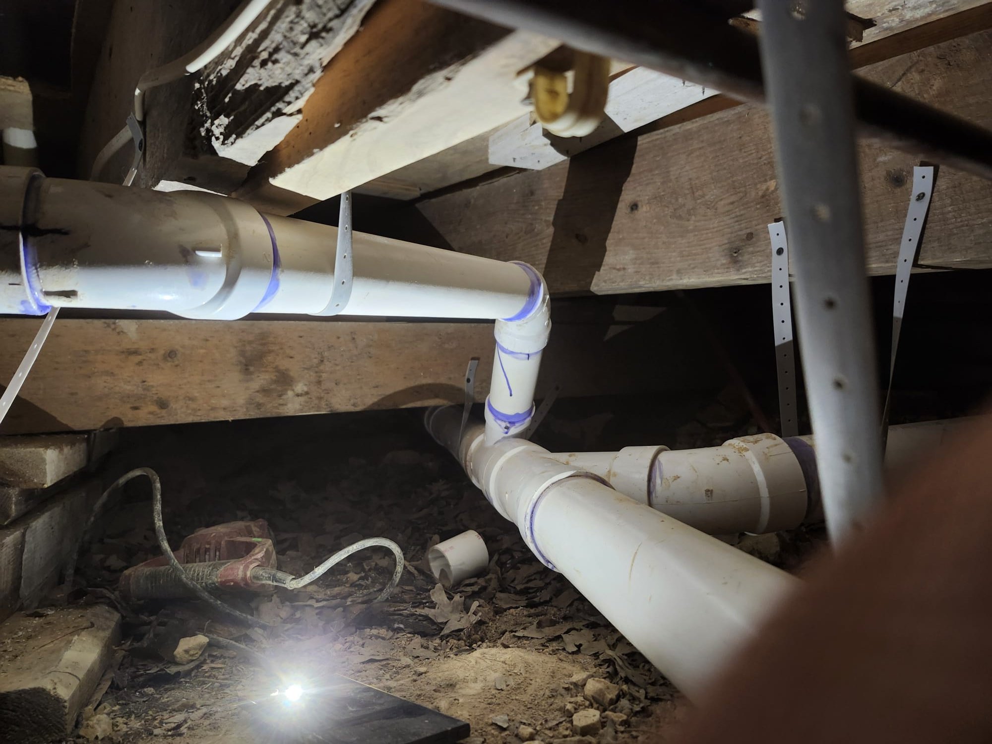 Freshly installed drain piping in a crawlspace under the home