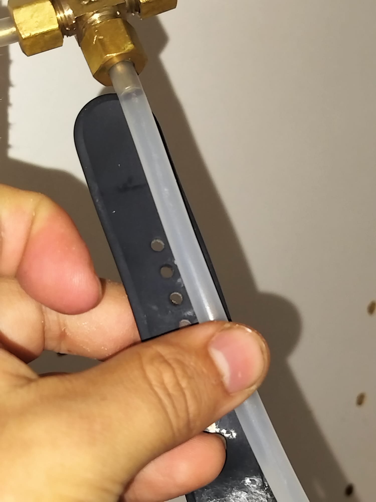 A brass fitting secured in place with a flexible line and support bracket